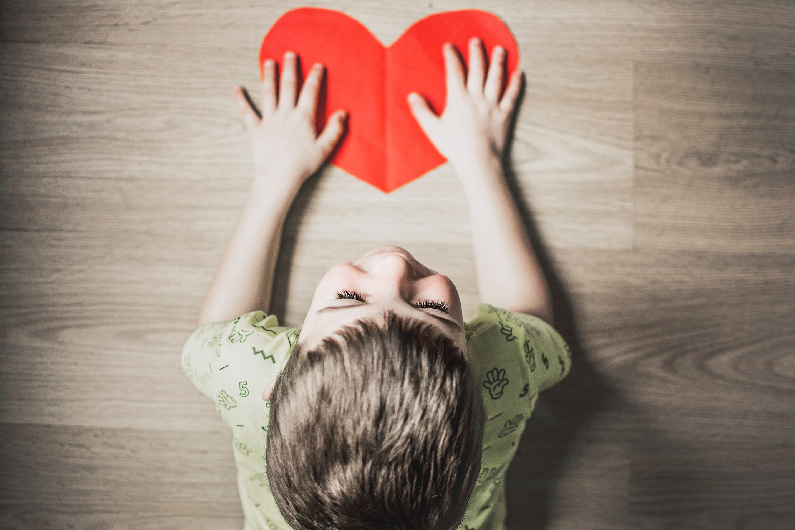 Child with a paper cutout in the shape of a heart